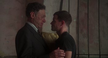 Movie still from “Midnight Express” (1978), directed by Alan Parker – A man and a man hug each other in a room; Medium shot, Over the shoulder angle