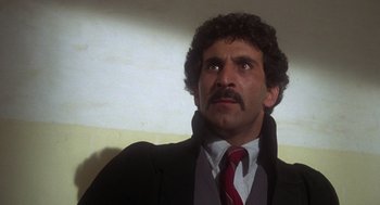 Movie still from “Midnight Express” (1978), directed by Alan Parker – A person wearing a suit and tie; Close Up shot, Low angle