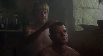 Movie still from “Midnight Express” (1978), directed by Alan Parker – A man getting his hair brushed by another man; Close Up shot, Low angle
