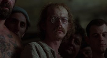 Movie still from “Midnight Express” (1978), directed by Alan Parker – A person wearing glasses and a beard; Close Up shot, Over the shoulder angle