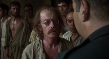 Movie still from “Midnight Express” (1978), directed by Alan Parker – A group of men standing next to each other in a room; Close Up shot, Over the shoulder angle