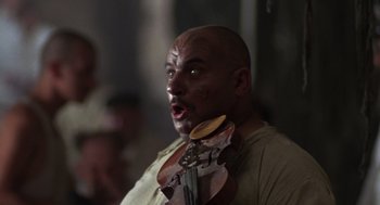 Movie still from “Midnight Express” (1978), directed by Alan Parker – A man with a violin in his hand and his mouth open; Close Up shot, Low angle