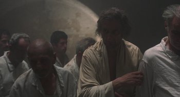 Movie still from “Midnight Express” (1978), directed by Alan Parker – A group of men standing around in a room; Medium shot, Low angle