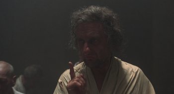 Movie still from “Midnight Express” (1978), directed by Alan Parker – A man in a robe is pointing to his face; Close Up shot, Over the shoulder angle