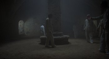 Movie still from “Midnight Express” (1978), directed by Alan Parker – Two men are walking in a dark room; Extreme Wide shot, High angle