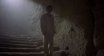 Movie still from “Midnight Express” (1978), directed by Alan Parker – A man standing in the middle of some steps in a cave; Wide shot, High angle