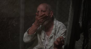 Movie still from “Midnight Express” (1978), directed by Alan Parker – An older man covering his mouth with his hands; Close Up shot, Low angle