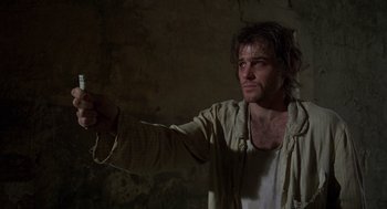Movie still from “Midnight Express” (1978), directed by Alan Parker – A man holding a gun in a dark room; Close Up shot, Low angle