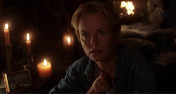Movie still from “Mighty Joe Young” (1998), directed by Ron Underwood – A woman sitting in front of a lit candle; Close Up shot, Over the shoulder angle