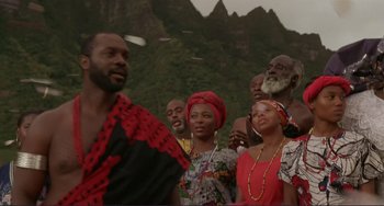 Movie still from “Mighty Joe Young” (1998), directed by Ron Underwood – A group of people standing in front of a mountain range; Medium shot, Low angle