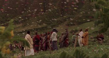 Movie still from “Mighty Joe Young” (1998), directed by Ron Underwood – A group of people standing on top of a grass covered hill; Extreme Wide shot, High angle