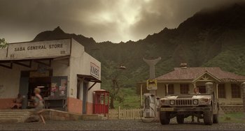 Movie still from “Mighty Joe Young” (1998), directed by Ron Underwood – A truck parked in front of a building on the side of the road; Extreme Wide shot, Low angle