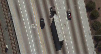 Movie still from “Mighty Joe Young” (1998), directed by Ron Underwood – An aerial view of a truck and cars on a highway; Extreme Wide shot, Overhead angle