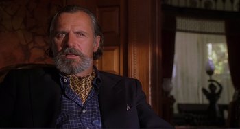 Movie still from “Mighty Joe Young” (1998), directed by Ron Underwood – An older man with a beard and a suit and tie; Close Up shot, Low angle