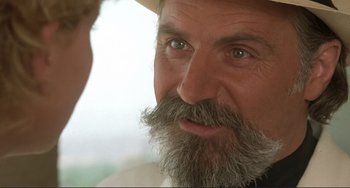 Movie still from “Mighty Joe Young” (1998), directed by Ron Underwood – An older man with a beard and a hat; Close Up shot, Over the shoulder angle