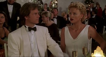 Movie still from “Mighty Joe Young” (1998), directed by Ron Underwood – A man and a woman sitting at a dinner table; Medium shot, Over the shoulder angle