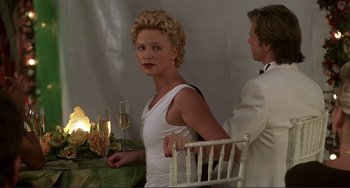 Movie still from “Mighty Joe Young” (1998), directed by Ron Underwood – A man and a woman sitting at a table with a glass of champagne; Medium shot, Over the shoulder angle