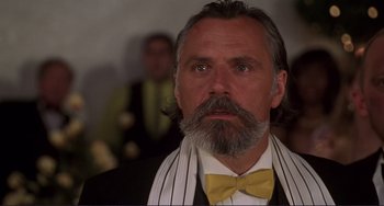 Movie still from “Mighty Joe Young” (1998), directed by Ron Underwood – A man with long grey hair wearing a yellow bow tie; Close Up shot, Low angle