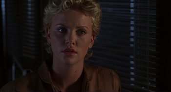 Movie still from “Mighty Joe Young” (1998), directed by Ron Underwood – A person with short blonde hair; Close Up shot, Over the shoulder angle