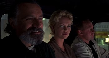 Movie still from “Mighty Joe Young” (1998), directed by Ron Underwood – A man and a woman in a car with another man; Close Up shot, Low angle