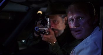 Movie still from “Mighty Joe Young” (1998), directed by Ron Underwood – A man with a camera taking a picture of another man with a camera; Close Up shot, Low angle