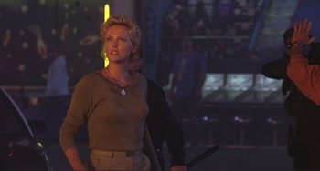 Movie still from “Mighty Joe Young” (1998), directed by Ron Underwood – A woman standing next to a man holding a sword; Medium shot, Over the shoulder angle