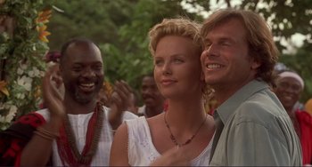 Movie still from “Mighty Joe Young” (1998), directed by Ron Underwood – A man and a woman standing next to each other in front of other people; Close Up shot, Over the shoulder angle