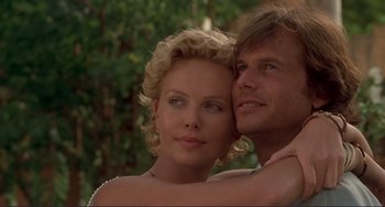 Movie still from “Mighty Joe Young” (1998), directed by Ron Underwood – A man and a woman embracing each other in front of trees; Close Up shot, Low angle