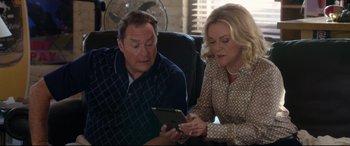 Movie still from “Mike and Dave Need Wedding Dates” (2016), directed by Jake Szymanski – A man and a woman looking at something on a tablet; Medium shot, High angle