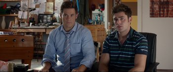 Movie still from “Mike and Dave Need Wedding Dates” (2016), directed by Jake Szymanski – Two young men sitting next to each other in a room; Medium shot, Over the shoulder angle