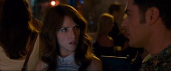 Movie still from “Mike and Dave Need Wedding Dates” (2016), directed by Jake Szymanski – A woman with long brown hair sitting in a room; Close Up shot, Over the shoulder angle