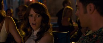 Movie still from “Mike and Dave Need Wedding Dates” (2016), directed by Jake Szymanski – A woman sitting at a table in front of other people; Close Up shot, Over the shoulder angle