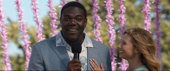 Movie still from “Mike and Dave Need Wedding Dates” (2016), directed by Jake Szymanski – A man holding a microphone in front of a woman; Close Up shot, Over the shoulder angle