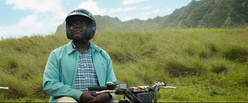 Movie still from “Mike and Dave Need Wedding Dates” (2016), directed by Jake Szymanski – A man with a helmet on sitting on a motorcycle in a grassy field; Medium shot, Over the shoulder angle
