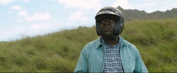 Movie still from “Mike and Dave Need Wedding Dates” (2016), directed by Jake Szymanski – A man wearing a motorcycle helmet standing in the grass; Close Up shot, Over the shoulder angle