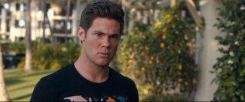 Movie still from “Mike and Dave Need Wedding Dates” (2016), directed by Jake Szymanski – A person wearing a black t - shirt; Close Up shot, Over the shoulder angle