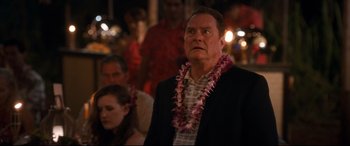 Movie still from “Mike and Dave Need Wedding Dates” (2016), directed by Jake Szymanski – A man wearing a lei standing in front of a crowd; Close Up shot, Over the shoulder angle
