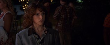 Movie still from “Mike and Dave Need Wedding Dates” (2016), directed by Jake Szymanski – A woman in a suit and tie standing next to other people; Close Up shot, Over the shoulder angle