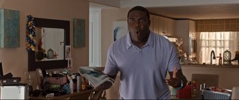 Movie still from “Mike and Dave Need Wedding Dates” (2016), directed by Jake Szymanski – A man holding a newspaper in a kitchen; Medium shot, Low angle