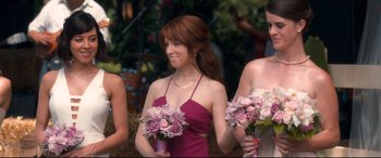 Movie still from “Mike and Dave Need Wedding Dates” (2016), directed by Jake Szymanski – A beautiful young lady in a purple dress holding flowers; Medium shot, Over the shoulder angle