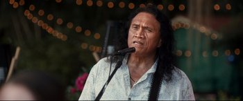 Movie still from “Mike and Dave Need Wedding Dates” (2016), directed by Jake Szymanski – A man with long black hair is holding a microphone; Close Up shot, Low angle