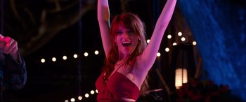Movie still from “Mike and Dave Need Wedding Dates” (2016), directed by Jake Szymanski – A beautiful woman in a red top raising her arms; Medium shot, Low angle