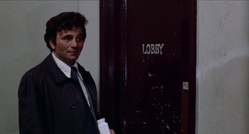 Movie still from “Mikey and Nicky” (1976), directed by Elaine May – A man standing in front of a lobby door; Medium shot, Over the shoulder angle