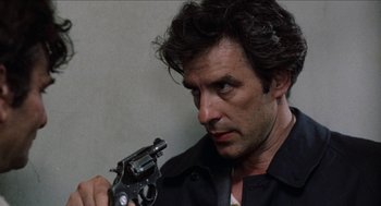Movie still from “Mikey and Nicky” (1976), directed by Elaine May – A person holding a gun; Close Up shot, Over the shoulder angle