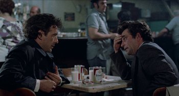 Movie still from “Mikey and Nicky” (1976), directed by Elaine May – Two men sitting at a table in front of each other; Medium shot, Over the shoulder angle