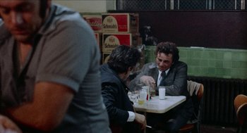Movie still from “Mikey and Nicky” (1976), directed by Elaine May – Two men sitting at a table in a restaurant; Medium shot, Over the shoulder angle