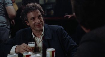 Movie still from “Mikey and Nicky” (1976), directed by Elaine May – A man sitting at a table holding a glass of beer; Close Up shot, Over the shoulder angle