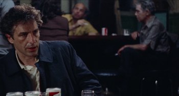 Movie still from “Mikey and Nicky” (1976), directed by Elaine May – A group of people sitting around a table; Close Up shot, Over the shoulder angle