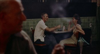 Movie still from “Mikey and Nicky” (1976), directed by Elaine May – A man and woman sitting at a table in a restaurant; Medium shot, Over the shoulder angle