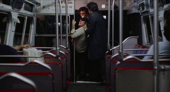 Movie still from “Mikey and Nicky” (1976), directed by Elaine May – Three men are standing on a public transit bus; Wide shot, Over the shoulder angle